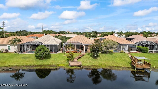 442 Carmel Dr, Melbourne, FL 32940 - rear view of house featuring a residential view, a tiled roof, a water view, and a lawn