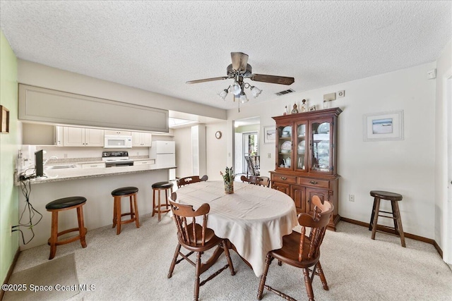 822 Berkshire Dr, Rockledge, FL 32955 - dining area featuring a ceiling fan, light colored carpet, and a textured ceiling