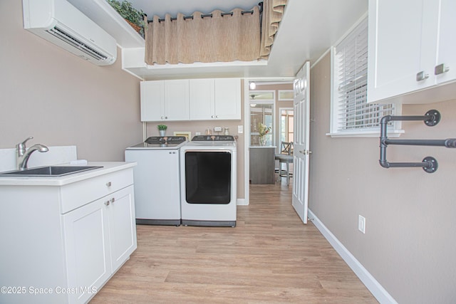 110 Windsong Way, Titusville, FL 32780 - washroom with separate washer and dryer, a wall mounted AC, cabinet space, and light wood-style floors