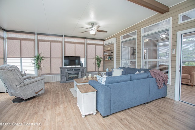 110 Windsong Way, Titusville, FL 32780 - living room with a ceiling fan, a wall mounted AC, wood finished floors, a fireplace, and a decorative wall