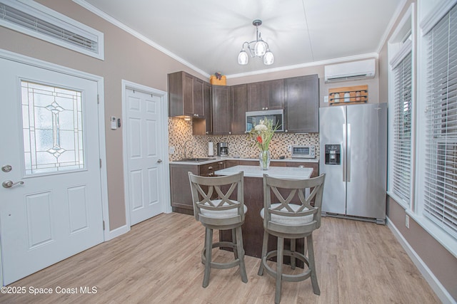 110 Windsong Way, Titusville, FL 32780 - kitchen with appliances with stainless steel finishes, a wall mounted air conditioner, dark brown cabinets, light wood-style flooring, and ornamental molding