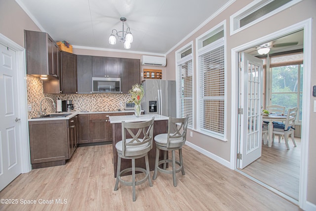110 Windsong Way, Titusville, FL 32780 - kitchen featuring stainless steel appliances, an AC wall unit, dark brown cabinetry, light wood-style floors, and decorative backsplash
