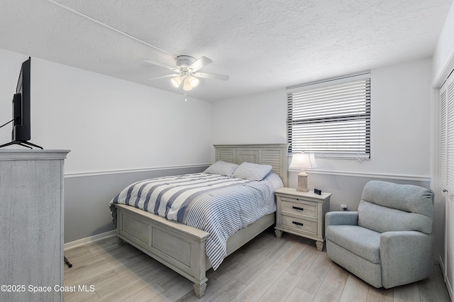 2101 S Atlantic Ave Unit 205, Cocoa Beach, FL 32931 - bedroom featuring light wood finished floors, a textured ceiling, and a ceiling fan