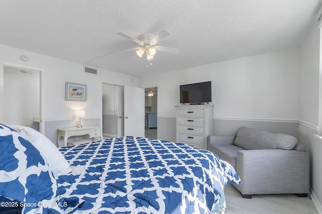 2101 S Atlantic Ave Unit 205, Cocoa Beach, FL 32931 - bedroom with a ceiling fan, a closet, a textured ceiling, and wood finished floors