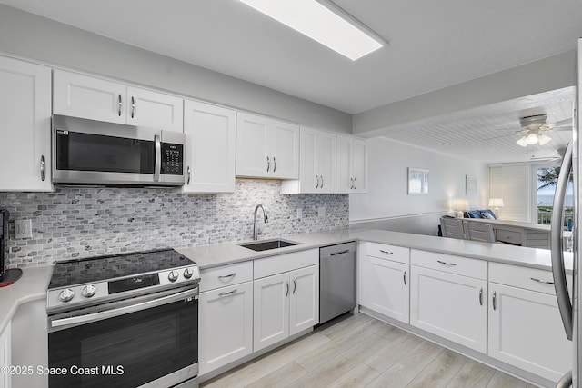 2101 S Atlantic Ave Unit 205, Cocoa Beach, FL 32931 - kitchen with stainless steel appliances, light countertops, white cabinetry, and ceiling fan
