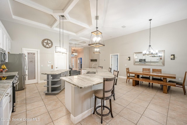 4333 Browning Ln, Rockledge, FL 32955 - kitchen featuring a chandelier, an island with sink, coffered ceiling, light tile patterned floors, and a towering ceiling