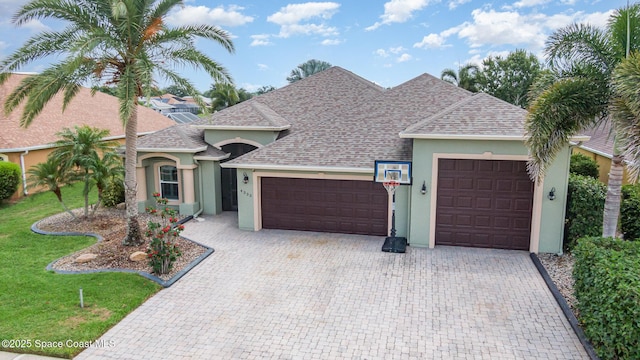 4333 Browning Ln, Rockledge, FL 32955 - view of front of house featuring stucco siding, an attached garage, a shingled roof, decorative driveway, and a front yard