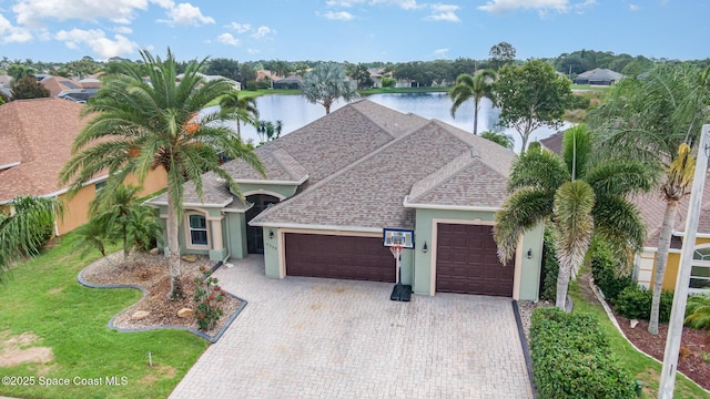 4333 Browning Ln, Rockledge, FL 32955 - view of front of property with an attached garage, a water view, stucco siding, decorative driveway, and roof with shingles