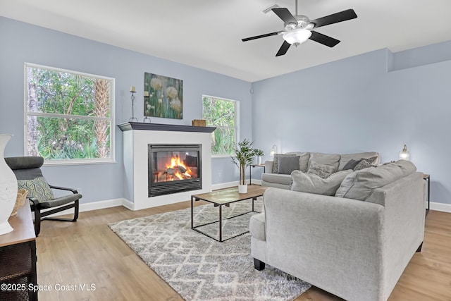 2559 Christopher Dr, Titusville, FL 32780 - living area featuring ceiling fan, a glass covered fireplace, and wood finished floors