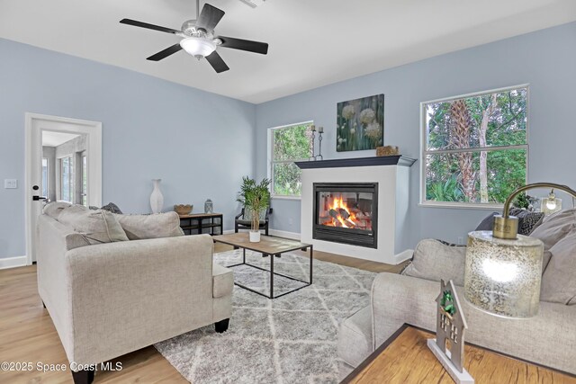 2559 Christopher Dr, Titusville, FL 32780 - living room with a glass covered fireplace, wood finished floors, and a ceiling fan