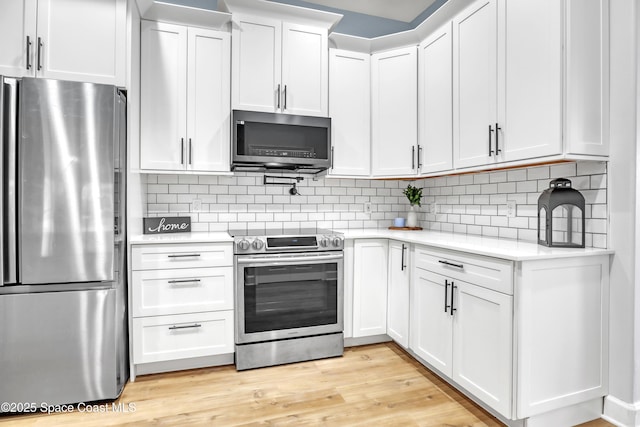 2559 Christopher Dr, Titusville, FL 32780 - kitchen featuring appliances with stainless steel finishes, light countertops, white cabinetry, and decorative backsplash