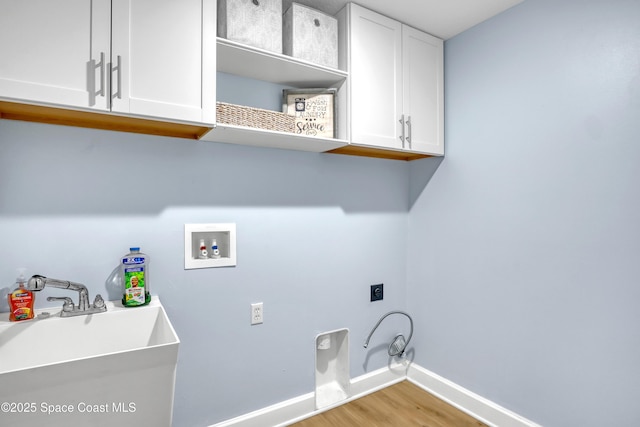 2559 Christopher Dr, Titusville, FL 32780 - laundry area featuring hookup for an electric dryer, washer hookup, light wood-type flooring, and cabinet space