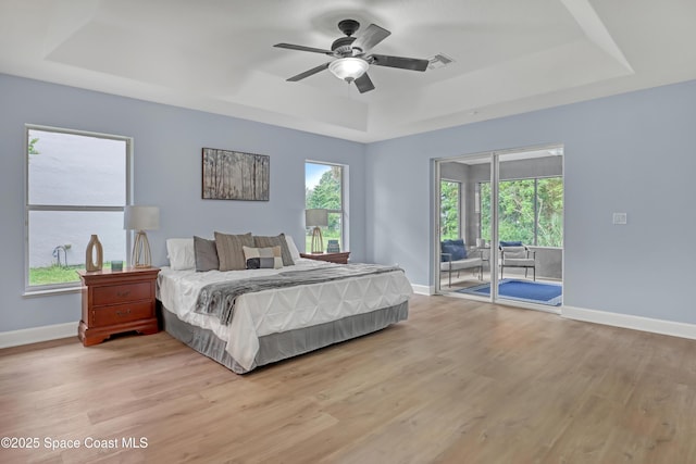 2559 Christopher Dr, Titusville, FL 32780 - bedroom with a tray ceiling, access to exterior, light wood-type flooring, and a ceiling fan