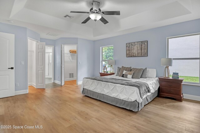 2559 Christopher Dr, Titusville, FL 32780 - bedroom featuring a raised ceiling, light wood finished floors, a spacious closet, and ceiling fan