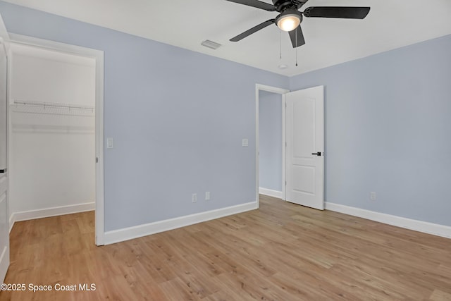 2559 Christopher Dr, Titusville, FL 32780 - unfurnished bedroom featuring a spacious closet, light wood-type flooring, and ceiling fan