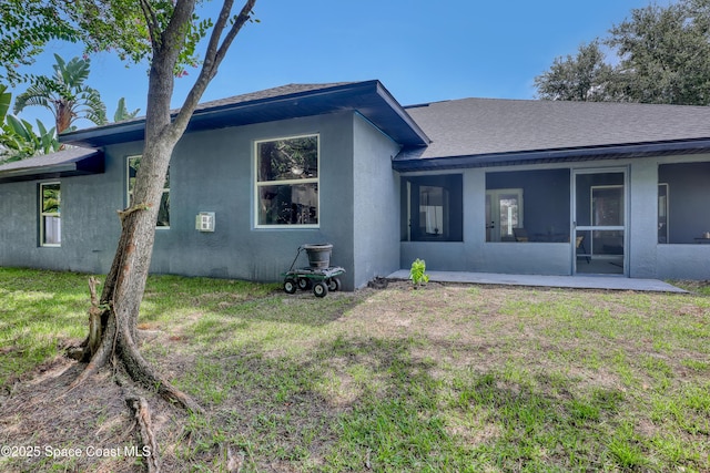 2559 Christopher Dr, Titusville, FL 32780 - back of house featuring stucco siding, a yard, and a shingled roof