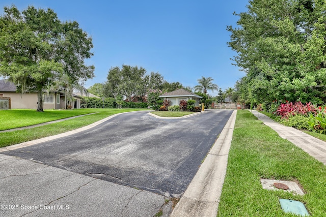 2559 Christopher Dr, Titusville, FL 32780 - view of asphalt street with sidewalks, curbs, and a gated entry