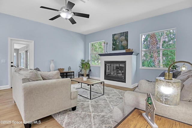 2559 Christopher Dr, Titusville, FL 32780 - living room featuring wood finished floors, ceiling fan, and a glass covered fireplace