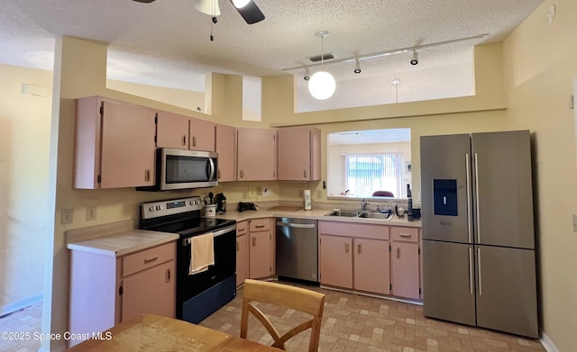 1469 California Dr, Melbourne, FL 32940 - kitchen with appliances with stainless steel finishes, light countertops, a textured ceiling, track lighting, and a ceiling fan