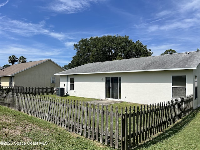 1469 California Dr, Melbourne, FL 32940 - rear view of house with stucco siding, a shingled roof, and a fenced backyard