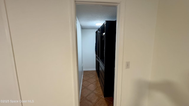 650 N Atlantic Ave Unit 406, Cocoa Beach, FL 32931 - hallway featuring a textured ceiling and tile patterned flooring