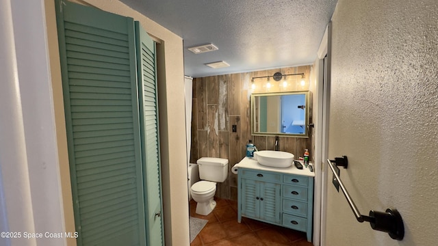 650 N Atlantic Ave Unit 406, Cocoa Beach, FL 32931 - bathroom featuring tile patterned flooring, vanity, a closet, a textured ceiling, and a textured wall