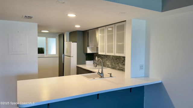 650 N Atlantic Ave Unit 406, Cocoa Beach, FL 32931 - kitchen with a breakfast bar, glass insert cabinets, tasteful backsplash, recessed lighting, and freestanding refrigerator