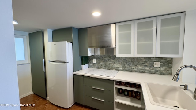 650 N Atlantic Ave Unit 406, Cocoa Beach, FL 32931 - kitchen featuring white appliances, decorative backsplash, light countertops, wall chimney exhaust hood, and glass insert cabinets