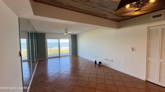 650 N Atlantic Ave Unit 406, Cocoa Beach, FL 32931 - empty room featuring dark tile patterned floors and ceiling fan