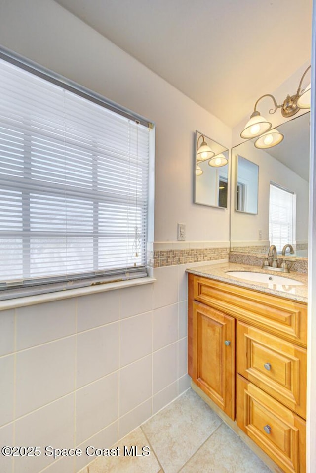 949 Brunswick Ln, Rockledge, FL 32955 - bathroom featuring tile walls, vanity, tile patterned flooring, and wainscoting