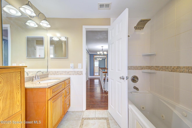 949 Brunswick Ln, Rockledge, FL 32955 - full bath with tile patterned floors, vanity, a chandelier, a combined bath / shower with jetted tub, and tile walls