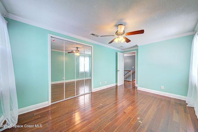 949 Brunswick Ln, Rockledge, FL 32955 - unfurnished bedroom featuring a textured ceiling, wood-type flooring, ornamental molding, a ceiling fan, and a closet