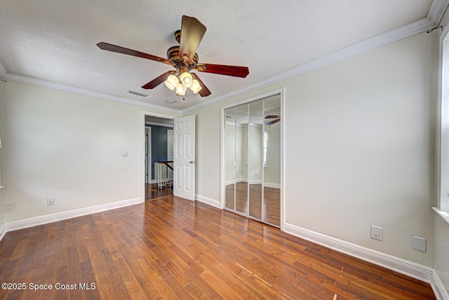 949 Brunswick Ln, Rockledge, FL 32955 - unfurnished bedroom featuring wood finished floors, a textured ceiling, crown molding, and a ceiling fan