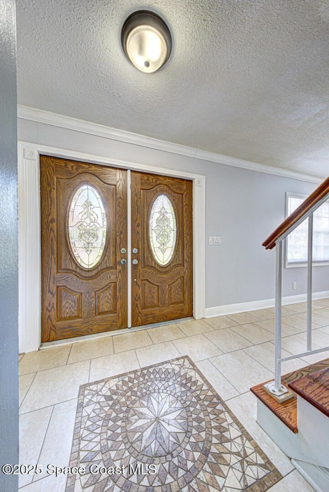 949 Brunswick Ln, Rockledge, FL 32955 - tiled foyer featuring plenty of natural light, ornamental molding, a textured ceiling, and stairway
