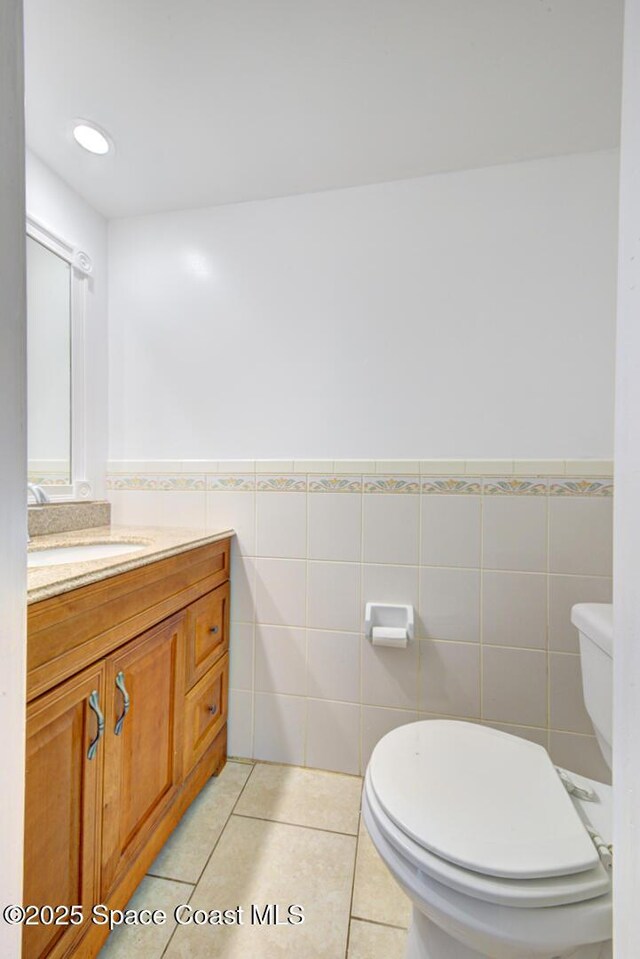 949 Brunswick Ln, Rockledge, FL 32955 - bathroom featuring tile walls, vanity, wainscoting, and tile patterned flooring