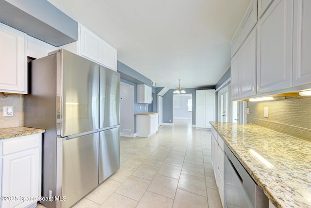 949 Brunswick Ln, Rockledge, FL 32955 - kitchen featuring appliances with stainless steel finishes, decorative backsplash, white cabinets, a chandelier, and light stone countertops