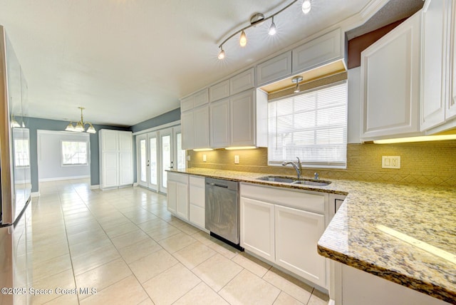 949 Brunswick Ln, Rockledge, FL 32955 - kitchen featuring stainless steel dishwasher, decorative backsplash, light tile patterned floors, and white cabinets
