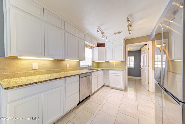 949 Brunswick Ln, Rockledge, FL 32955 - kitchen featuring appliances with stainless steel finishes, white cabinetry, backsplash, and light stone counters
