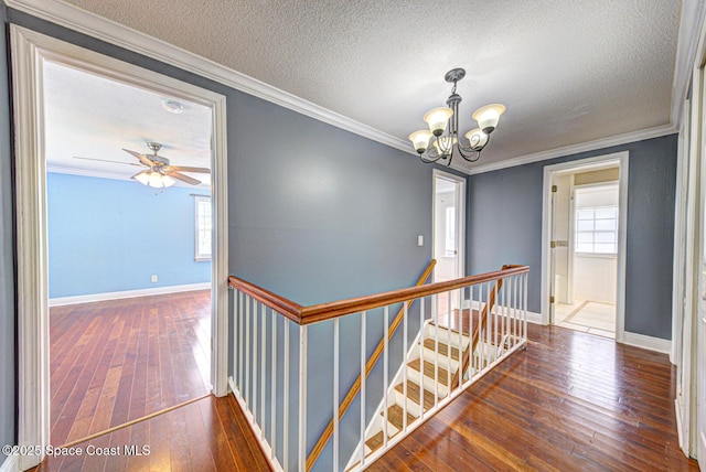 949 Brunswick Ln, Rockledge, FL 32955 - hallway with an upstairs landing, a chandelier, a textured ceiling, hardwood / wood-style flooring, and ornamental molding
