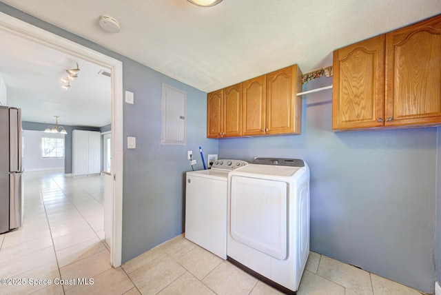 949 Brunswick Ln, Rockledge, FL 32955 - laundry area featuring cabinet space, washing machine and dryer, electric panel, and light tile patterned floors