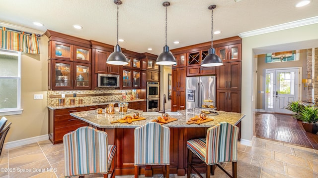 2683 Amati Dr, Kissimmee, FL 34741 - kitchen featuring appliances with stainless steel finishes, backsplash, stone tile floors, a breakfast bar area, and recessed lighting