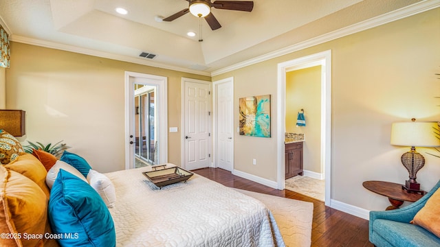 2683 Amati Dr, Kissimmee, FL 34741 - bedroom featuring dark wood-style floors, a tray ceiling, recessed lighting, crown molding, and connected bathroom