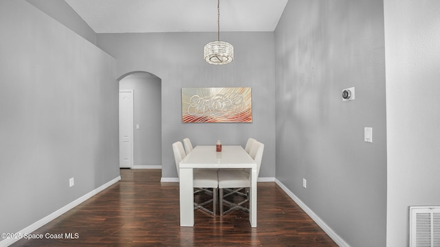 1119 Macon Dr, Titusville, FL 32780 - dining room with arched walkways, wood finished floors, and a chandelier