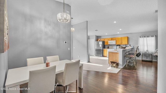 1119 Macon Dr, Titusville, FL 32780 - dining room with a chandelier, light wood-type flooring, and recessed lighting