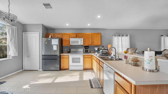 1119 Macon Dr, Titusville, FL 32780 - kitchen featuring white appliances, a peninsula, light countertops, light tile patterned floors, and recessed lighting