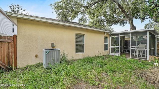 1119 Macon Dr, Titusville, FL 32780 - rear view of house with a sunroom and stucco siding