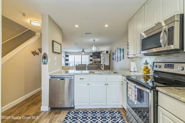 57 Broad St Unit 6, Titusville, FL 32796 - kitchen with stainless steel appliances, decorative backsplash, light wood-style floors, recessed lighting, and a ceiling fan