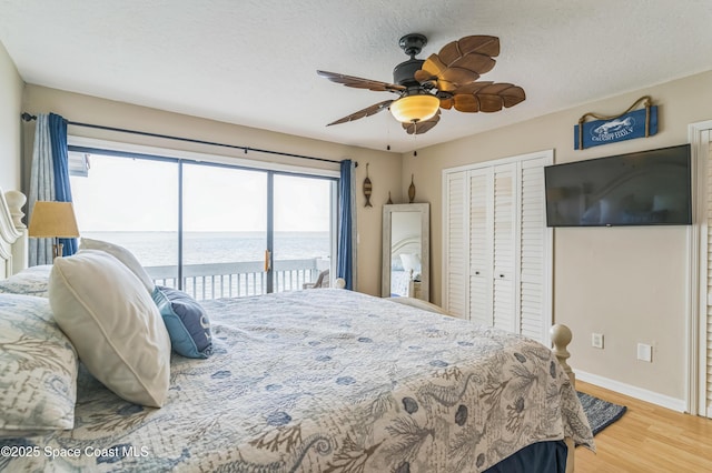 57 Broad St Unit 6, Titusville, FL 32796 - bedroom featuring access to exterior, light wood finished floors, a closet, a ceiling fan, and a textured ceiling
