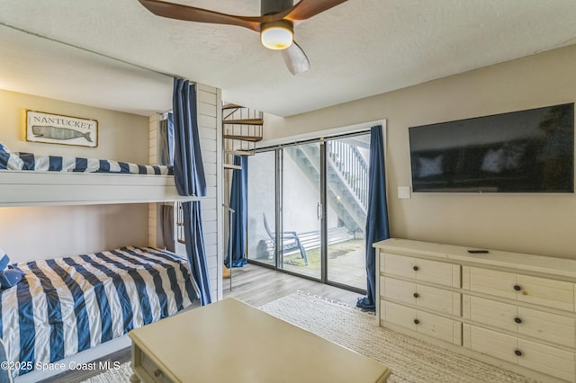 57 Broad St Unit 6, Titusville, FL 32796 - bedroom featuring access to exterior, wood finished floors, a textured ceiling, and ceiling fan