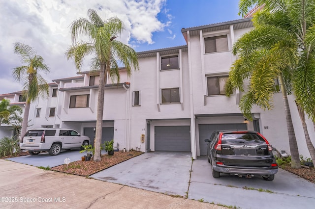 57 Broad St Unit 6, Titusville, FL 32796 - view of front facade featuring stucco siding, concrete driveway, and an attached garage